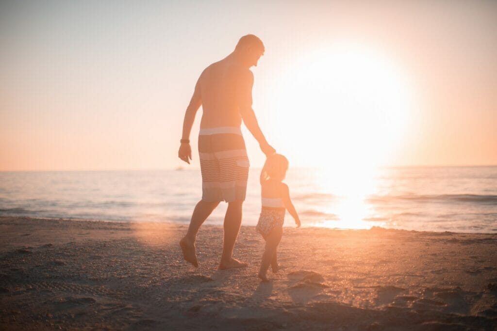 A Mesmerizing Sunset Beach Scene: A Father and Son's Special Bond - Walking Hand in Hand, Creating Cherished Memories by the Serene Shoreline