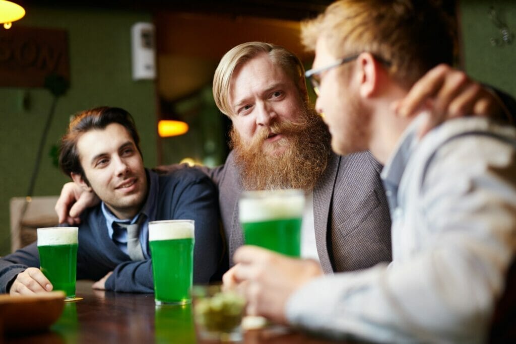 At the bustling beer bar, two pals take a seat at the counter, placing up a verbal exchange with some other guy over beers, building a newfound camaraderie through lively discussions about travel.
