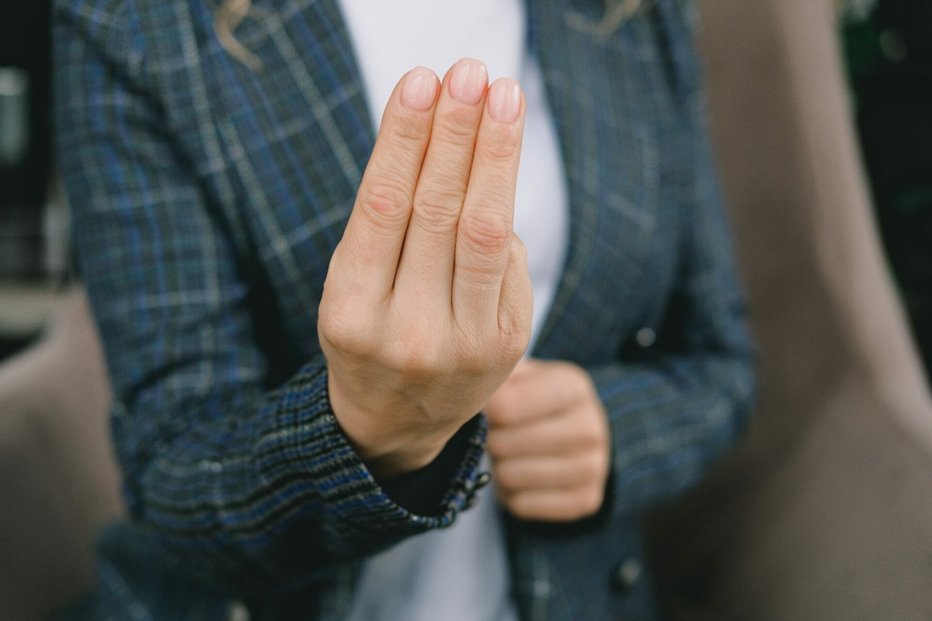 Image depicting various types of body language: A woman standing, using hand gestures to convey messages.