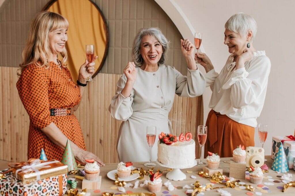 "Three elderly girls joyfully celebrate 'Happy Birthday to the Mother of My Grandchildren' in a comfy room. A pleasant birthday cake bearing '60 years' rests at the desk, surrounded by delectable treats. Their heartfelt joy fills the room as they commemorate this special occasion." happy birthday to the mother of my grandchildren

